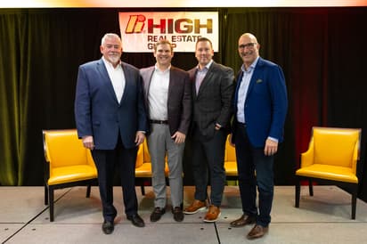HREG male executive leaders standing on stage 